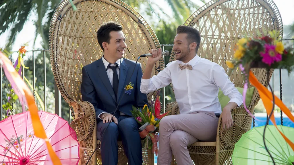 Grupo de invitados celebrando una boda LGTBI con cena al aire libre en ambiente festivo